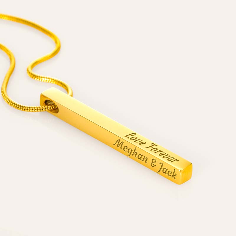 Gold necklace with engraved message on a white background