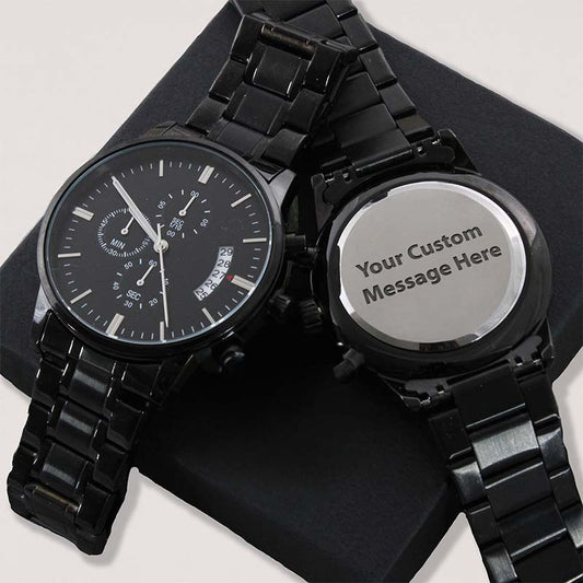 Two black metal link wristwatches on a black display stand, one showing a black chronograph-style dial and the other showing a blank silver-toned back with the text 'Your Custom Message Here'.