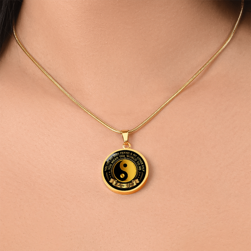 Gold necklace with a black and gold yin yang sign on the circle pendant customized with sentimental message, on a woman's neck.