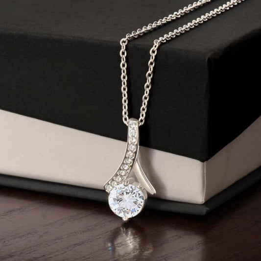 Silver Ribbon necklace with a zirconia crystal centered pendant on a two-tone gift box.
