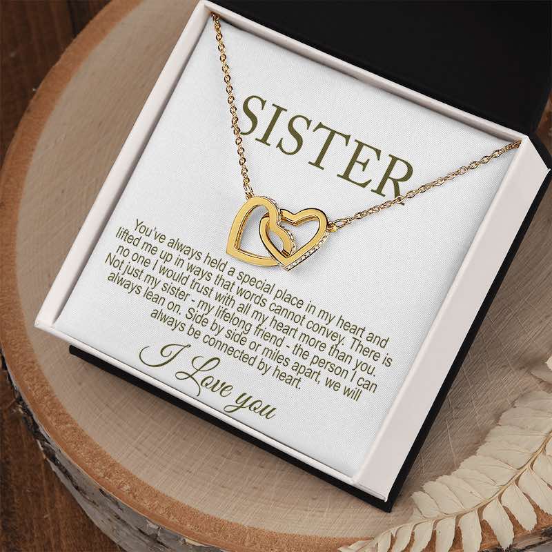 Gold necklace with interlocking hearts on a 'Sister' card with a special message displayed in a gift box.