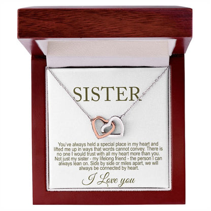 Necklace with interlocking hearts in a wooden box with a card message for sister inside.