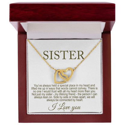 Gold necklace with interlocking hearts and a 'Sister' card with thoughtful message in a luxury box